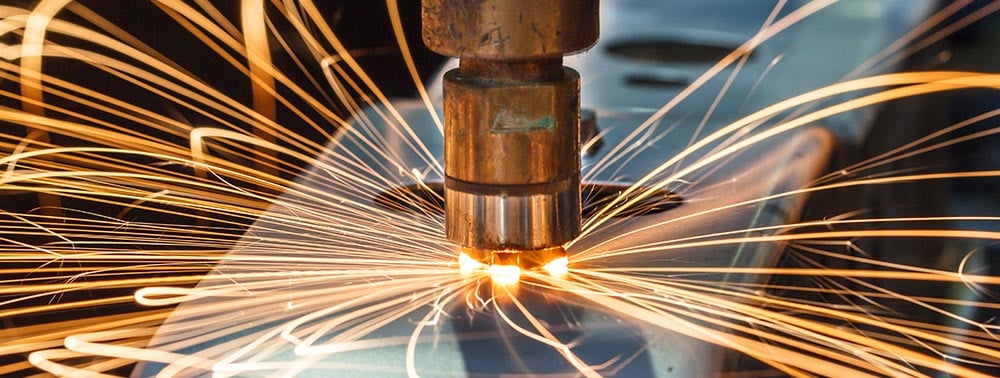 Sparks fly during industrial metal stamping process. 